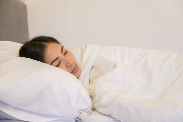Hermosa mujer durmiendo en la almohada blanca en el dormitorio - Foto, imagen