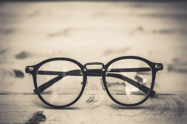 Black frame clear glasses on vintage table background - Photo, Image