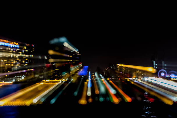 光のボケと水面反射を背景に夜の街のぼかし - 写真・画像