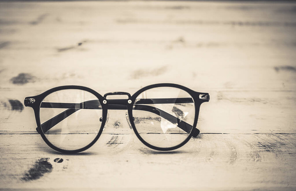 Black frame clear glasses on vintage table background - Fotoğraf, Görsel