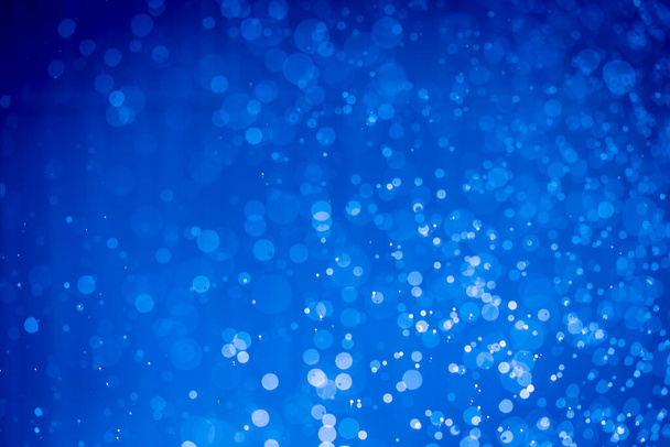 Abstraktní tmavě modré vánoční třpytky světla rozostřené pozadí bokeh - Fotografie, Obrázek