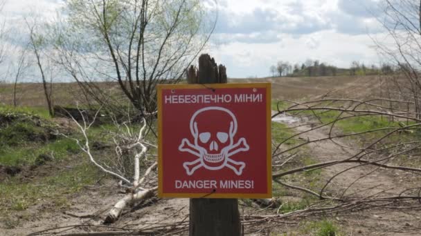 Ein Schild mit einer Inschrift auf Ukrainisch und Englisch Danger of mines - Filmmaterial, Video