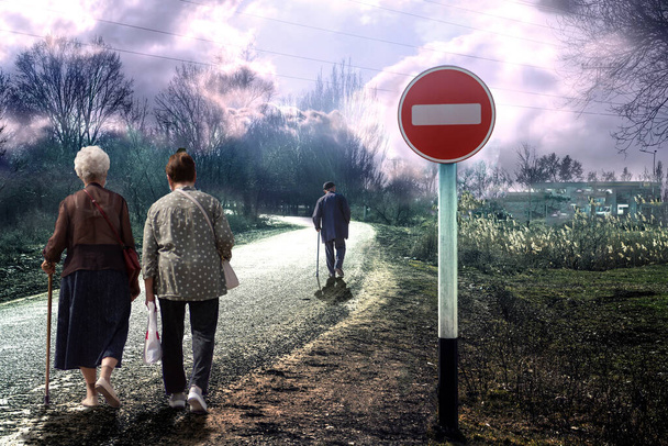 Personnes âgées sur la route sous un panneau de signalisation interdisant. - Photo, image