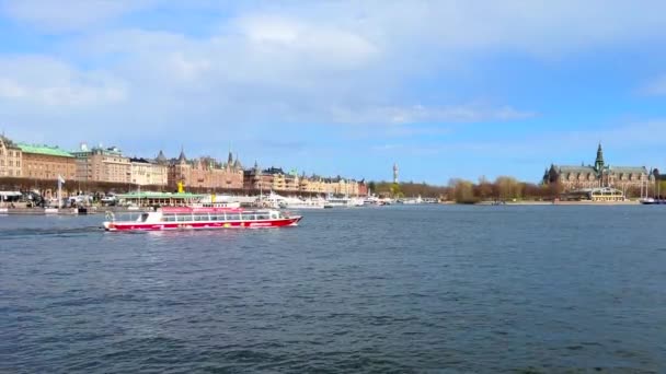 Stockholm, Švédsko - 23. dubna 2022: Pohled na moře a budovy v bohatší části města Stockholm s vyhlídkovou lodí opouštějící přístav - Záběry, video