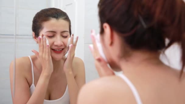 Mujer asiática feliz limpia la piel con espuma en el baño. - Imágenes, Vídeo