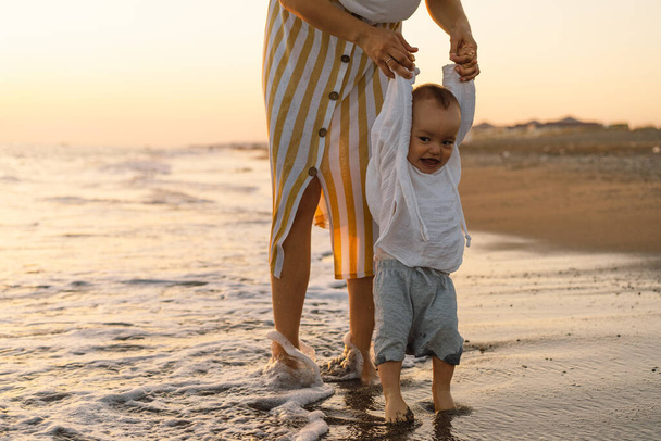 Szczęśliwego Dnia Matki. Piękna matka i dziecko bawią się na plaży. - Zdjęcie, obraz