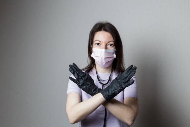 female doctor in black gloves with phonendoscope prohibits. danger concept - Foto, Imagen