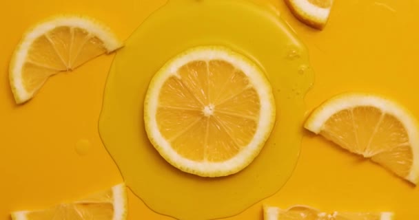 Top view rotation of fresh slice of lemons juice and gel serum, organic cosmetics, vitamin C, fresh citrus fruits, Lemon extract - Séquence, vidéo