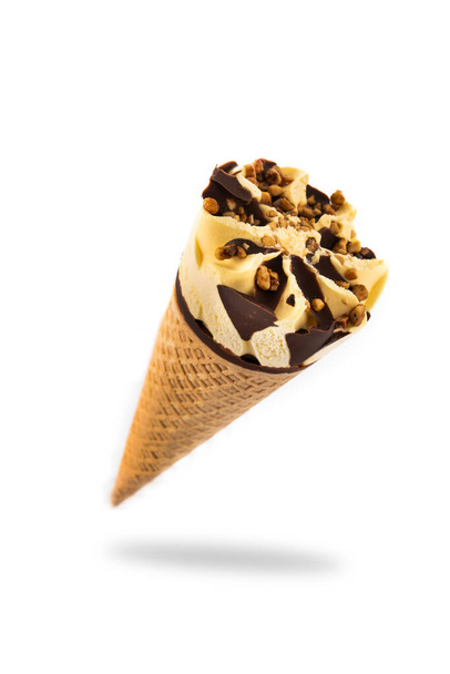 白い背景に隔離された空気中に浮かぶバニラとチョコレートのアイスクリームコーン - 写真・画像