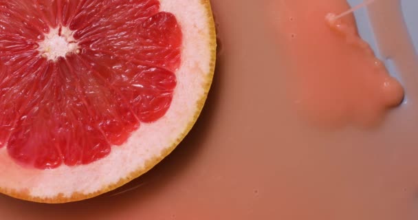 Top view of fresh slice of grapefruits juice and gel serum pours, organic cosmetics, vitamin C, fresh citrus fruits, grapefruit extract - Filmagem, Vídeo