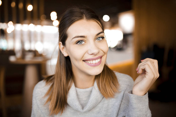 Portrait of a cute girl with beautiful smile in a cafe. - Foto, Imagem