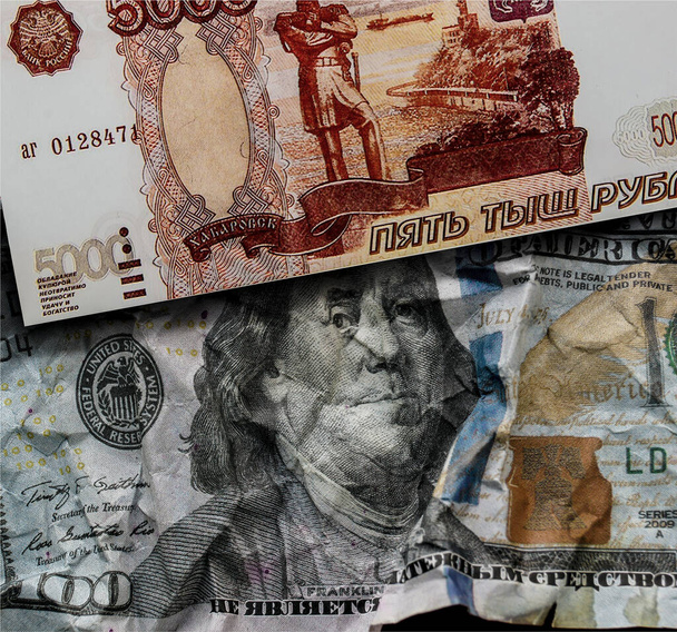Смятый доллар США поверх доллара не является смятым российским рублём. Символ слабости доллара. - Фото, изображение
