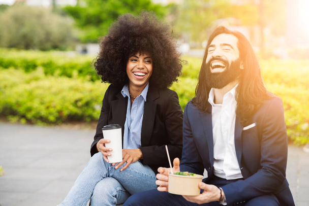 compañeros de trabajo multirraciales sonriendo mientras almorzaban en el descanso en la calle de la ciudad - centrarse en la mujer afroamericana - - Foto, Imagen