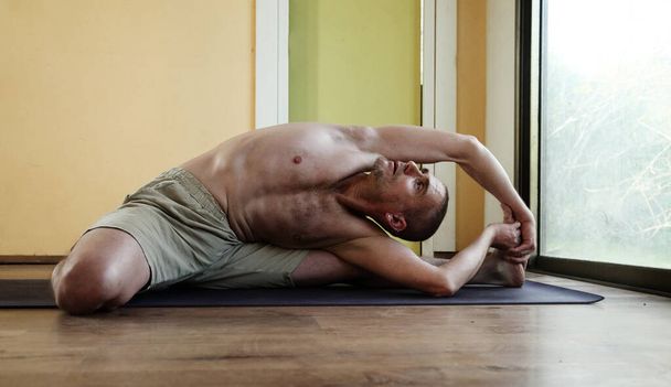 Yoga lesson. A man practices yoga at home - Foto, Imagem