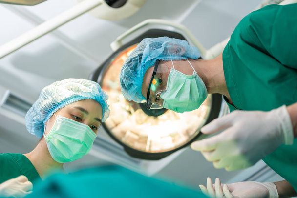 Matala kulma Shot of Professional kirurgit joukkue suorittaa leikkauksen leikkaussalissa, kirurgi, Avustajat, ja sairaanhoitajat Suorittavat leikkauksen potilaan, terveydenhuollon syöpä ja sairauksien hoito käsite - Valokuva, kuva