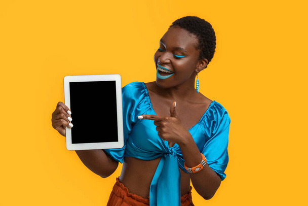Excited black woman pointing at digital tablet, mockup - Photo, image