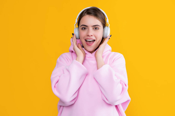 positive girl listen music in headphones on yellow background - Fotó, kép