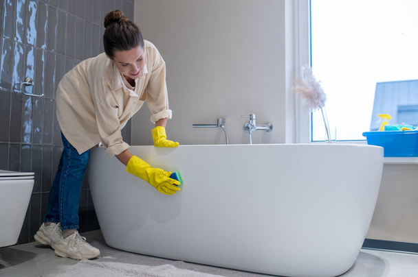 A woman doing cleaning at home and disinfecting the bathroom - Photo, Image