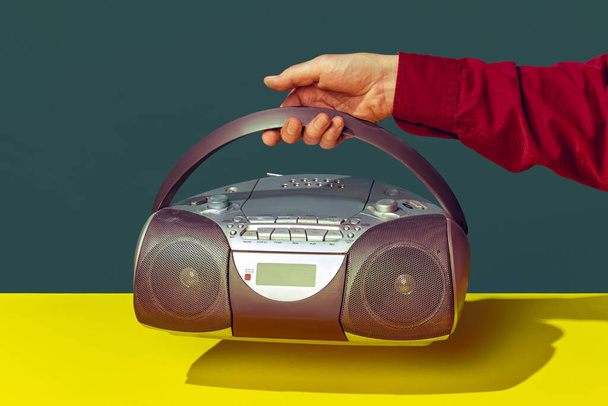 Colorful image of vintage radio player on bright yellow tablecloth isolated over dark green background - Φωτογραφία, εικόνα