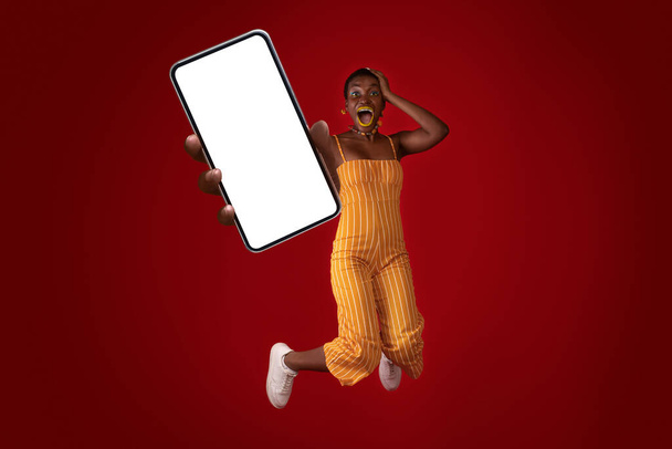 Duygusal stil Afrikalı Amerikalı kadın cep telefonunu boş ekranla gösteriyor. - Fotoğraf, Görsel