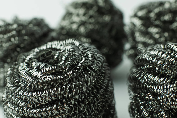close up view of abrasive metal scourers on grey background - Foto, afbeelding