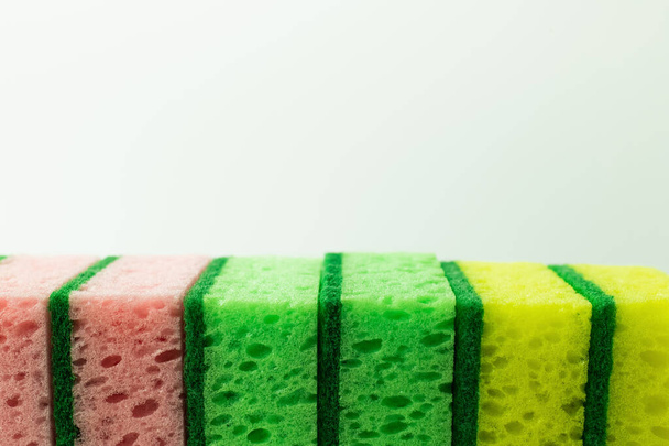 close up view of pink, green and yellow porous sponges isolated on grey - 写真・画像