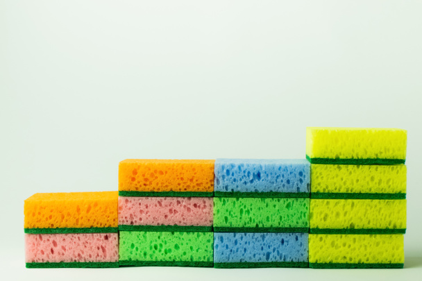 stack of porous multicolored sponge scourers on grey background - Foto, imagen