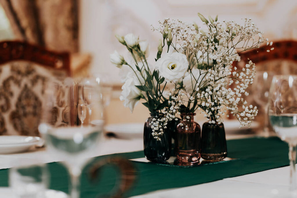 On the table a beautiful arrangement of flowers during a wedding banquet - Fotoğraf, Görsel