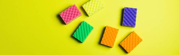 top view of multicolored cleansing sponges on yellow background, banner - Photo, image
