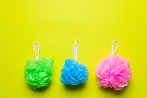 top view of green, blue and pink body puffs on yellow background - Fotoğraf, Görsel