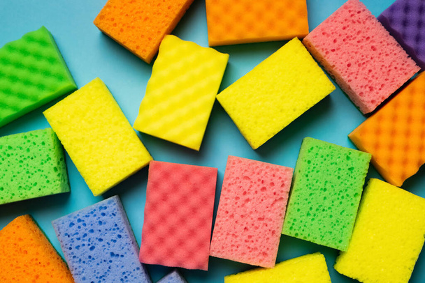 plenty of multicolored washcloths on blue background, top view - Photo, Image