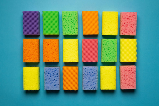 top view of different colorful kitchen washcloths on blue background - 写真・画像