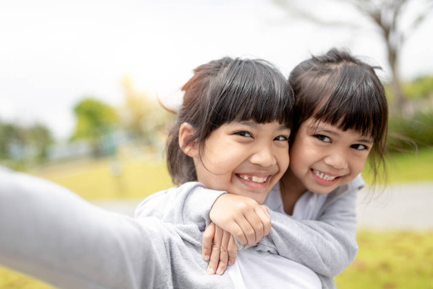 Happy Asian child takes a selfie in the park. - Foto, Imagem