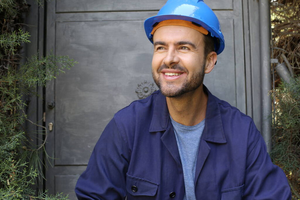 close-up portrait of handsome young worker in uniform with helmet - Photo, Image