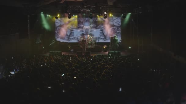 Concert. This stock video shows a concert in full swing. The moving head lights illuminate the excited crowd as they dance and sway to the music. Use this clip for TV and movie sequences, event commercials, music videos, social media posts - Materiaali, video