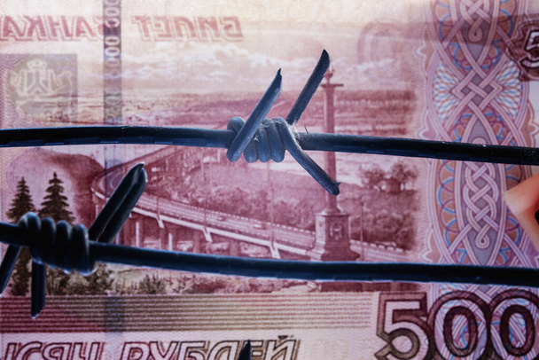 Le concept de guerre, les sanctions et la dévaluation du rouble. Gros plan de fil barbelé sale contre l'argent russe. - Photo, image