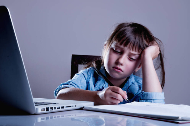 Girl is bored studying online. Negative aspects of distance learning. - Foto, Bild