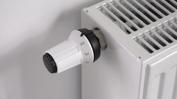 El hombre establece el termostato del radiador de calefacción en modo de economía media - Metraje, vídeo