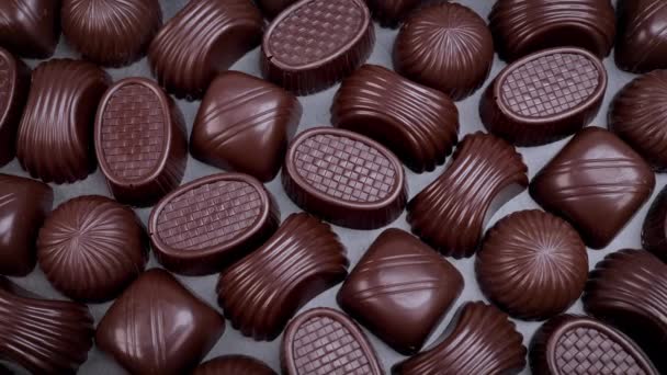 Tmavá čokoláda rozmanité pralinky na černém pozadí. Miluje čokoládu a sladkosti. Dolly shot 4k - Záběry, video