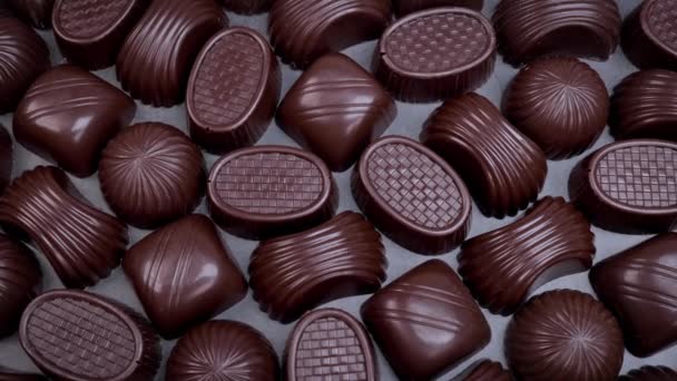 Tmavá čokoláda rozmanité pralinky na černém pozadí. Miluje čokoládu a sladkosti. Dolly shot 4k - Záběry, video