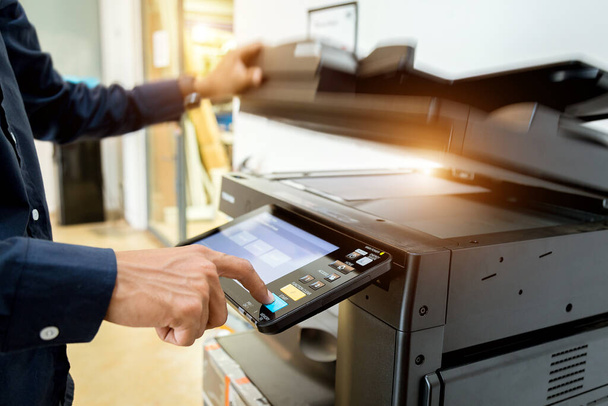 Zakenman Handdrukknop op printerpaneel, printer scanner laser kantoor kopieermachine levert startconcept. - Foto, afbeelding