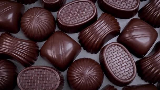 Pralinen aus dunkler Schokolade auf schwarzem Hintergrund. Liebevolle Schokolade und Süßigkeiten Konzept. Dolly Schuss 4k - Filmmaterial, Video