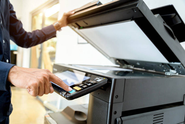 Hombre de negocios Pulse el botón de mano en el panel de la impresora, escáner de impresora láser oficina copiar suministros concepto de inicio. - Foto, imagen