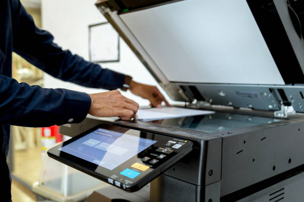 Bussiness man Hand press button on panel of printer, printer scanner laser office copy machine supplies start concept. - Photo, image