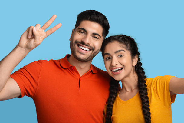 Boldog fiatal arab pár fotózás Selfie együtt a kék háttér - Fotó, kép