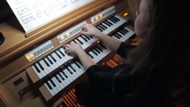 Junge Frau spielt elektronische Orgel nach Noten - Filmmaterial, Video