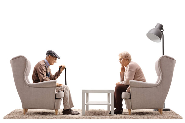 Sad elderly man and woman sitting in armchairs isolated on white background - Fotografie, Obrázek