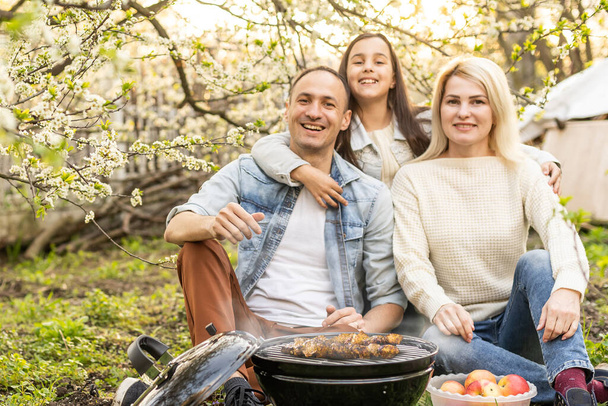 Família feliz ter churrasco com churrasqueira moderna ao ar livre
 - Foto, Imagem