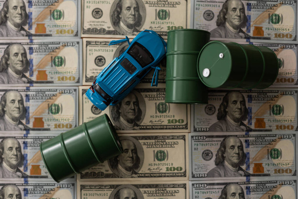 barrels of oil standing on the dollar bills of money. the oil business, purchase sale, production, exchange, trading income. - Photo, Image