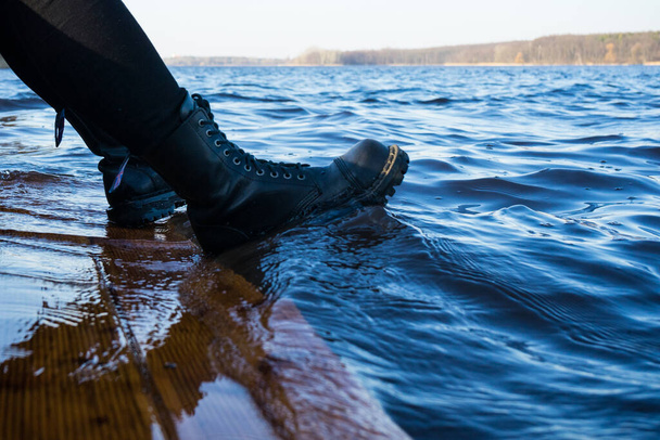 Waves wash over black leather boots with high lacing - Foto, immagini